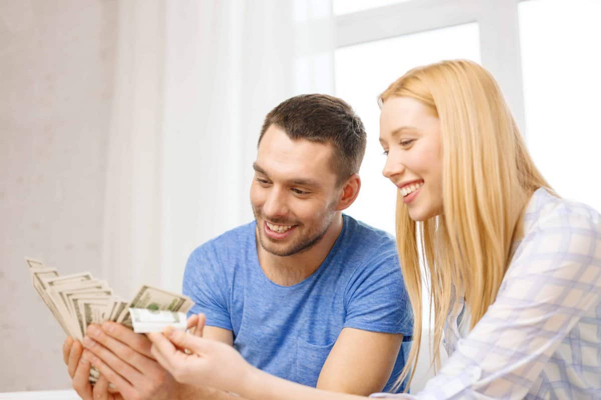 A man and a woman are looking at money, possibly discussing how TANF can help their family.