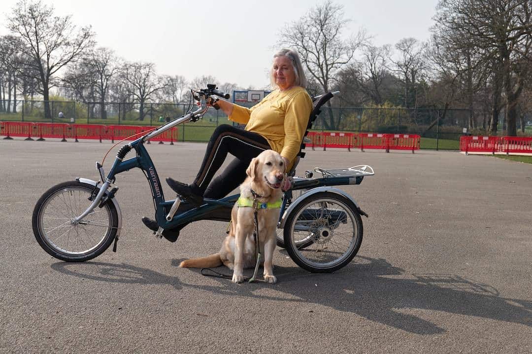 A woman rides a bike with her dog while benefiting from Medicaid.